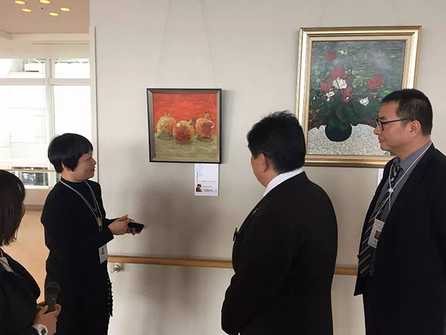 廣州青年美術(shù)家協(xié)會副主席楊健女士，為到場嘉賓、政府官員導(dǎo)賞參展佳作.jpg